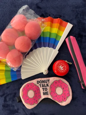 Leksaker  - Säljer leksaker. En solfjädrar i regnbågsfärger, en rosa sovmask med donutmotiv, ett röd yo-yo, ett rosa mini pennfack samt ”lockbollar”. Perfekt för dig som gillar färg och roliga prylar!