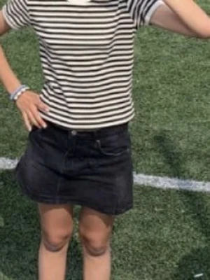 Svart jeanskjol med fickor - Säljer en svart jeanskjol med klassisk femficksdesign och bälteshällor. Kjolen är kort och har en rak passform som passar till det mesta. Perfekt för dig som gillar en enkel men snygg stil.