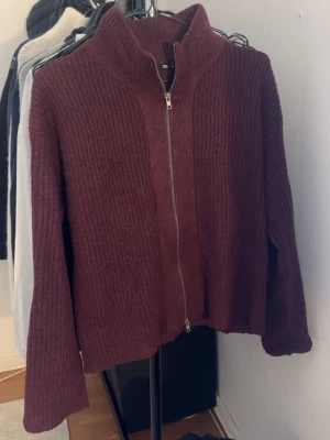 Vinröd stickad kofta från 157 - Mysig vinröd stickad kofta från 157 i storlek XS. Koftan har hög krage, grovstickad struktur och hel dragkedja framtill. Perfekt för lager på lager under kyliga dagar. Är i ett mycket bra skick🥰