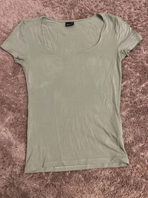 Ljusgrön topp från Gina Tricot - Säljer en enkel och stilren ljusgrön topp från Gina Tricot i storlek XS. Toppen har rundad urringning och korta ärmar. Perfekt att matcha med jeans eller kjol för en clean look. Passar mycket bra på mig även om jag brukar ha stl-s/m 