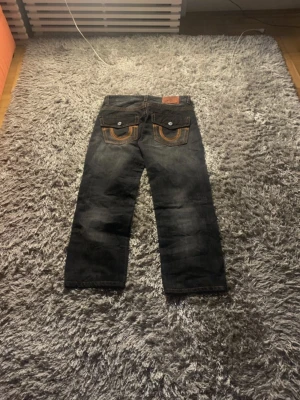 2006 True Religion - Super nice and good looking true religion jeans theyre very comfortable and look great. They are also almost fully new the only inperfection is the back tag that is a little torn but besides that theyre 100% authentic and if you have any questions or offers im open!🙂  Measurements📊 Lentgh 95cm Width 45cm Leg opening 20cm