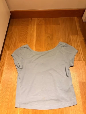 Ljusblå croppad topp från Cubus - En enkel och stilren ljusblå croppad topp från Cubus. Toppen har korta ärmar och rundad halsringning. Tillverkad i mjuk bomull som känns skön mot huden. Perfekt till jeans eller kjol för en avslappnad look.