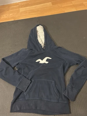 Hollister  - En riktigt kön hoodie från hollister med il i luvan. Storlek S men står att det är L. Kolla så att måtten passar, längd 58cm bredd 51cm och  armlängd 53 cm