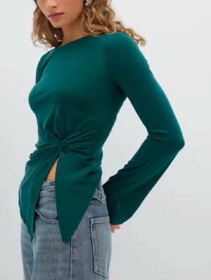 Grön långärmad topp med knyt - Snygg mörkgrön långärmad topp med knyt i sidan som skapar en cool twist och slits framtill. Toppen har en figurnära passform och är tillverkad i mjukt material som känns skönt mot huden. Perfekt att styla med jeans eller kjol.