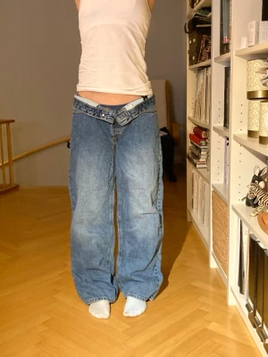 Blå baggy jeans med låg midja - Säljer ett par baggy blå jeans med låg midja och breda ben. Klassisk femficksmodell i jeansmaterial och avslappnad passform. Perfekta för dig som gillar loose fit och streetwear-vibe.🌸Kolla in mina andra annonser!💕