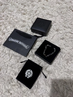 Chrome Hearts bracelet - Bilderna visar ett armband från Chrome Hearts med tillhörande förpackning, men ingen väst finns med.
