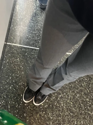 Gråa raka kostymbyxor - Säljer ett par stilrena gråa bootcut kostymbyxor med låg midja från Nelly. Byxorna har en klassisk look och är tillverkade i ett mjukt tyg som ger en snygg siluett. Perfekta för dig som gillar en clean och enkel stil.