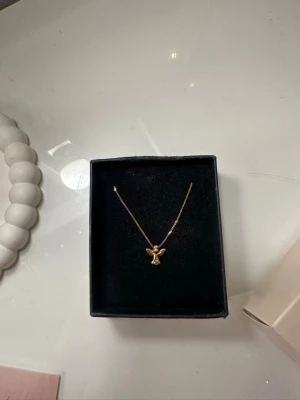 Guld halsband  - Äkta guldhalsband 18k med kristall  Fick i present så vet inte vilket märke på halsbandet och har tyvärr ingen original låda till den.  På sista bilden ser du en likadan ängel fast med vit sten som sitter på halsbandet