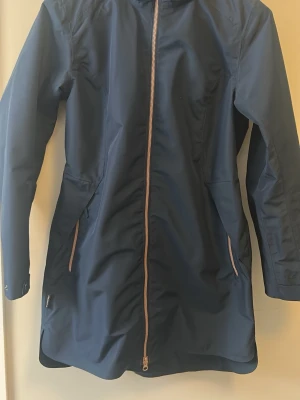 Mörkblå vårjacka från Everest - Snygg mörkblå vårjacka från Everest med huva och hel dragkedja i kontrastfärg. Jackan har långa ärmar, två fickor med dragkedja och en lätt insvängd midja för en schysst passform. Perfekt våriga dagar ute.