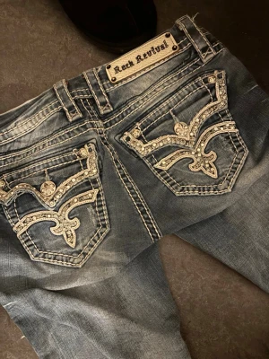 Rock revival jeans - Jätte coola, y2k jeans. Lågmidjade och bootcut modell. Har inga defekter alls. Säljer dessa pga att de ej kmr t användning. Köpta för 2000kr. Jag som är 1,62 lång sitter dem lagom på. 
