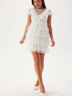 Vit spetsklänning - Superfin vit kort klänning i spets med flera lager volanger och v-ringad detalj framtill. Klänningen har korta ärmar och är tillverkad i ett tunt, spetsigt material som ger en luftig känsla. Perfekt för sommarens alla tillfällen! Klänningen kommer från Bubbleroom i storlek S. Helt oanvänd, lappen sitter kvar och klänningen skickas i orginalpåse☺️