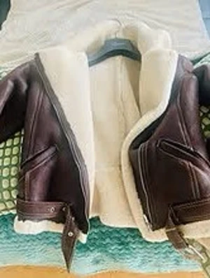 Brun fårskinnsjacka med bälte, stl M - Säljer en brun fårskinnsjacka i klassisk pilotstil med vit fluffig insida och bred krage. Jackan har bälte i nederkant, dragkedja och snedställda fickor. Perfekt för dig som vill ha en varm och snygg jacka med vintagevibbar.