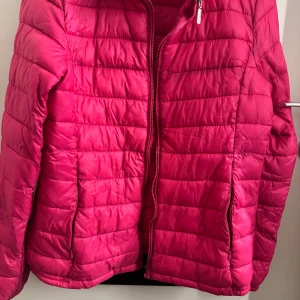 Moncler lättvikts dunjacka i rosa  - Säljer en snygg moncler lättvikts dunjacka i rosa den har några år på sig men jag måste ändå säga att den är välbehållen, tycker jag men alla tycker olika. Den har quiltade sömmar och praktisk bra skick dragkedja framtill. Jackan har två sidofickor och är tillverkad i lätt syntetmaterial, perfekt för kyliga dagar. Passformen är normal och jackan har långa ärmar. Skickar direkt när betalning skett så köpare kan börja använda så snabbt det går. En självklarhet för mig. Då jag gillar det jag säljer
