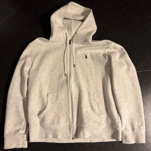 Ljusgrå hoodie från Polo Ralph Lauren - Snygg ljusgrå hoodie från Polo Ralph Lauren med klassisk broderad logga på bröstet. Använd 2-3 gånger, inga fläckar. Fits TTS