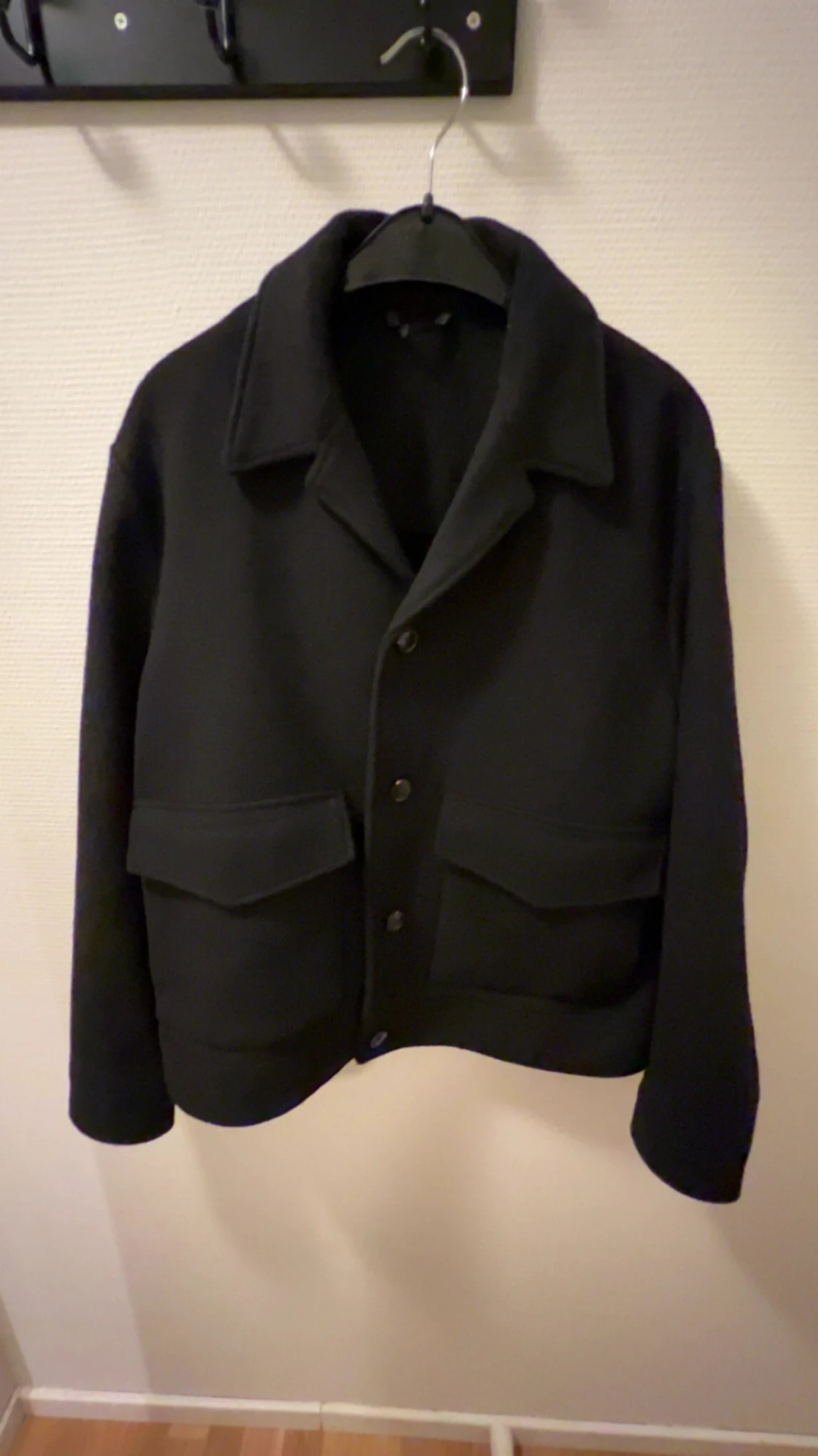 Svart kappa med dubbla fickor