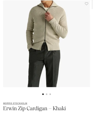 Beige zip-kofta från Morris Stockholm - Snygg beige zip-kofta från Morris Stockholm med ribbad struktur och hel dragkedja framtill. Koftan har en klassisk krage och långärmade ärmar, perfekt för lager-på-lager. Passar dig som gillar stilrena och enkla plagg med modern touch.