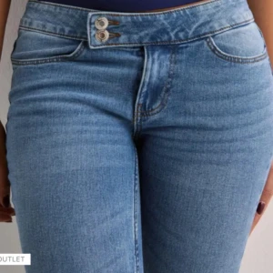 Blå bootcut jeans från Vero Moda - Snygga blå bootcut jeans från Vero Moda med dubbla knappar i midjan och klassisk femficksdesign. Jeansen har en lätt utsvängd passform nertill och är tillverkade i ett mjukt denimtyg. Perfekta för dig som gillar en retroinspirerad look. Jeansen är rätt så långa i längden och priset kan absolut diskuteras💗