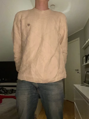 Beige stickad tröja med mönster - Snygg chill tröja från chaps by Raulph lauren i färgen beige. Tröjan är i storlek L och modellen är 183 cm och väger ca 73 kilo. Snyggt mönster på tröjan vilket gör den mer unik! Tröjan är i 100% bomull vilket gör den väldigt skön👍