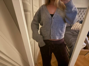 Grå croppad kofta med knappar - Grå croppad kofta med v-ringning och två framfickor. Koftan är super mjuk och från & other stories 
