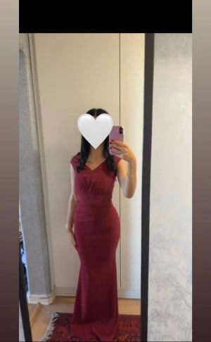 Vinröd maxiklänning med v-ringning, bubbleroom - Säljer en elegant vinröd långklänning med v-ringad hals och figurnära passform. Klänningen har breda axelband och går in tight i midjan. Perfekt för bröllop eller fester. Endast använd en gång!