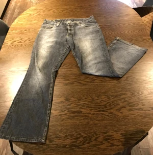 Grå bootcut jeans från Lee - Säljer ett par grå bootcut jeans från Lee då de tyvärr inte passar mig längre. Jeansen är låg/normala i midjan och är i storlek 32-33, men jag skulle mer anse att de är i storlek 36. Jag är 160cm lång och de passar mig bra i längden.