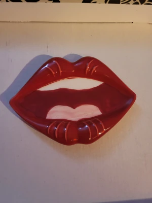 Lips and mouth accesserary - This fun dish is sure to liven any room! The inside of the mouth, teeth, and tounge are one flat surface. The lips are raised and have textured line details. Can be used as outfit accessory, trinket dish, soap dish, ashtray, decorative item, or something else.  Roughly 13×9cm at widest parts.  Small signs of wear are visible if you look very closely, otherwise in great shape.
