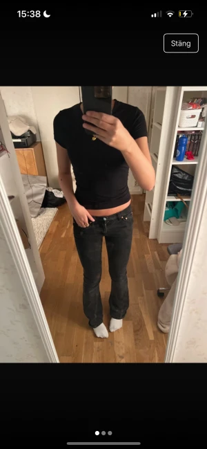 Svarta bootcut jeans låg midja - Säljer ett par svarta jeans med bootcut-snitt och låg midja. Jeansen har klassisk femficksdesign, knapp och dragkedja fram. Materialet är jeans och färgen är mörk svart. Perfekt för dig som gillar en avslappnad och trendig look.