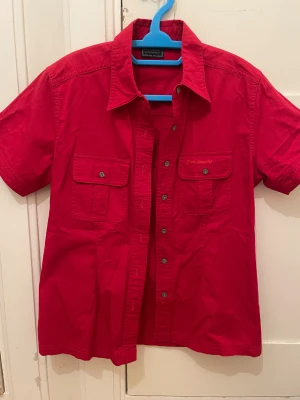 Röd kortärmad skjorta  - Riktigt snygg röd skjorta från FiveSeasons med korta ärmar och klassisk krage. Storlek 40 (barn), passar 10-11Y