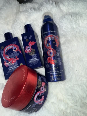 Rituals Legend of the Dragon set - Snyggt set från Rituals med blå och röda förpackningar med drakmotiv. Innehåller handtvål, handkräm, duschskum och kroppsskrubb med doft av plommon och cederträ. Lyxig design och perfekt för dig som gillar orientaliska dofter. Dehär är en Limited edition som inte säljes längre därav högre pris .vill du bara köpa en sak och inte allt så kommer styck priserna här helt ny handwads 180kr , helt ny handbalm 200kr,helt ny shower foam 200kr ,golden body scrub halva kvar 120kr. Passa på att köpa nu!