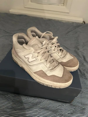 Beige vita New Balance 550 sneakers - Säljer ett par New Balance 550 sneakers i beige och ljusbrun färg. Skorna har klassisk snörning, rund tå och platt sula. Storlek 42. Bra skick, använts sparsamt, 7/10. Ny pris: 1299kr.
