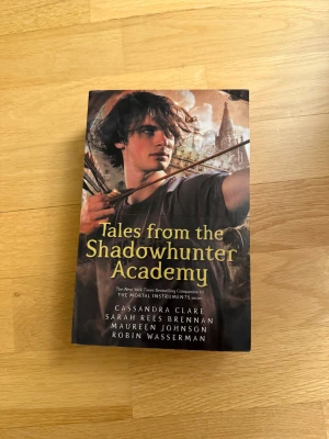 Tales from the Shadowhunter Academy English  - En spännande samling berättelser från Shadowhunter-världen! Perfekt för dig som gillar äventyr, fantasy och magiska skolor. Upptäck nya sidor av favoriterna från The Mortal Instruments och följ Simon Lewis på hans resa.