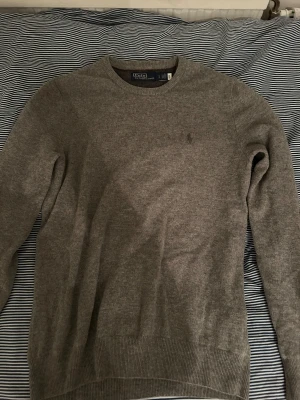 Grå stickad tröja från Polo Ralph Lauren - Snygg grå stickad tröja från Polo Ralph Lauren i storlek S. Stor i storleken. Mycket bra kick: 9/10. Nypris: 1800kr 