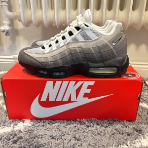 Nike Air Max 95  - Nike Air Max 95 sneakers i grått och vitt med svarta detaljer. Skorna har en ikonisk vågig design. Riktigt skönta skor till vinterns instprlek 42.