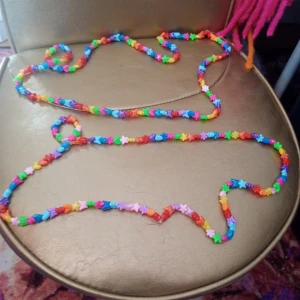 Färgglatt pärlhalsband (midjesmycke) med stjärnor - Superlångt halsband med pärlor i regnbågens alla färger. Pärlorna är formade som stjärnor, hjärtan och blommor vilket ger ett lekfullt och unikt uttryck. Perfekt för dig som vill sticka ut och addera färg till din outfit.