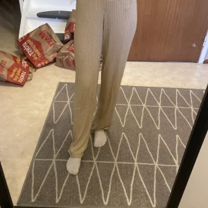 Beige ribbade byxor från SOC - Säljer ett par beige ribbade byxor från SOC i storlek S. Byxorna har hög midja och raka ben med en skön loose passform. Tillverkade i mjukt material som passar perfekt för en chill och avslappnad stil.