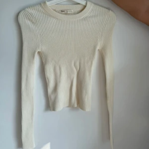 Ribbad beige tröja från Pull&Bear - Snygg ribbad beige tröja från Pull&Bear i storlek S. Tröjan har långärmad design och rund halsringning, med en slim passform som sitter riktigt bra. Perfekt att styla med jeans eller kjol för en clean och fräsch look.