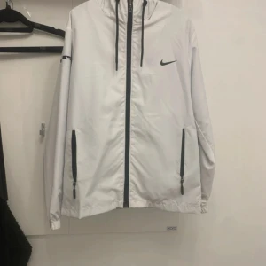 Nike jacka  - Nike kofta/jacka. Väldigt tunn har inte alls använts men en liten håll inne i koftan/jackan. OBS INTE ÄKTA 