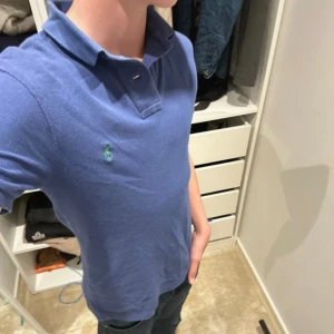 Blå pikétröja Polo Ralph Lauren XS - Säljer en blå pikétröja från Polo Ralph Lauren i slim fit-modell. Tröjan har klassisk krage, korta ärmar och den ikoniska gröna loggan broderad på bröstet. Tillverkad i mjuk bomull som är skön mot huden. Perfekt för en clean och stilren look. Såklart äkta och om ni har frågor är det bara att höra av er😁