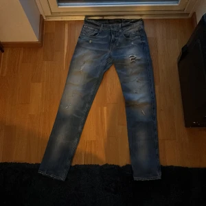 Replay anbass jeans blå - Vi säljer dessa blåa replay anbass jeansen med slitningar. Jeansen är i storleken 29/32. Värt att nämna är att etiketten saknas på insidan, se på sista bilden. Vid fler frågor och funderingar kan ni skriva. Pris kan diskuteras.