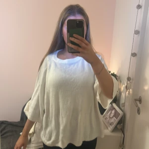 Vit oversized stickad tröja - Säljer en vit oversized stickad tröja med trekvartsärmar och rund hals. Tröjan har en lös och luftig passform, perfekt för lager på lager och chill stil. Superenkel att matcha med jeans eller leggings.