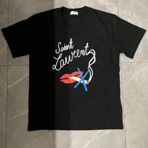 Saint Laurent t-shirt - Säljer nu den här feta Saint laurent t-shirten med ett riktigt nice tryck. Den är i väldigt bra skick och har använts sparsamt. Har tyvärr inget kvitto därav priset. Skriv vid minsta fråga/fundering👌
