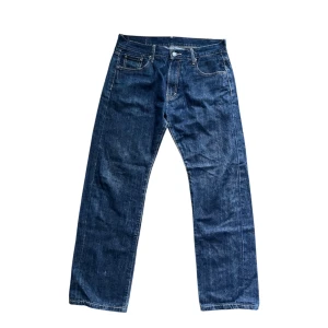 Levi's 505 jeans - Klassiska Levi's 505 jeans i mörkblå denim med raka ben och normal passform. Byxorna har fem fickor, bälteshällor och ikonisk röd Levi's-tag på bakfickan. Perfekta för dig som gillar en tidlös och avslappnad stil.