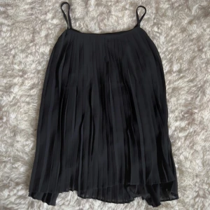 Svart plisserat linne från Golden Live - Supersnygg svart plisserat linne med tunna axelband från Golden Love. 