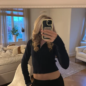 Marinblå stickad hoodie  - Säljer en mörkblå croppad hoodie med dragkedja framtill och långa ärmar. Tröjan har ribbade muddar och en huva, perfekt för en chill och snygg look. Passformen är slim och materialet känns mjukt och stickat. Som ny, storlek M men passar även xs och s💗 hör av er vid frågor💗