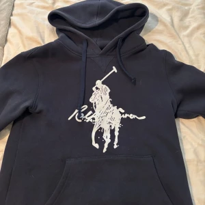 mörkblå hoodie från Polo Ralph Lauren - mörkblå hoodie från Polo Ralph Lauren med stor vit logga. Det är bara skriva vid funderingar💌