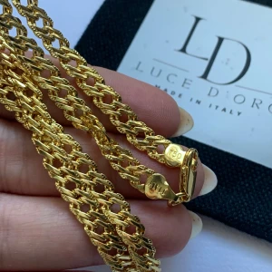 Exklusiv Bismark halsband Luce D'Oro med stämpel  - Snyggt halsband från Luce D'Oro, tillverkat i Italien. Kedjan är i guldtonad metall med flätad design och robust karbinlås. Märkt med 750 och Italy på låset, vilket ger en exklusiv känsla. Perfekt för dig som vill ha en statement piece med lyxig vibe.