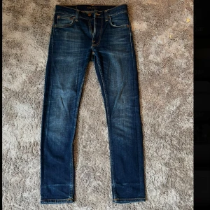 Nudie jeans lean Dean - Snygga mörkblå jeans från Nudie Jeans med klassisk femficksdesign i modellen lean Dean. Jeansen har raka ben och diskret slitning och är i storlek 27/30. Hör av er vid frågor!