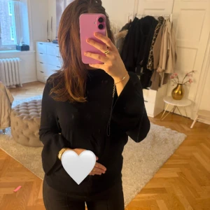 Svart stickad tröja med trumpetärmar - Svart finstickad tröja med snygga trumpetärmar och rund hals. Tröjan har en klassisk passform och är perfekt för dig som gillar stilrena och enkla plagg med en twist. Passar till allt och är superenkel att styla till olika looks.