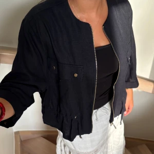 Mörkblå linnejacka/kofta med snörning - Snygg linnejacka/kofta från Zara med dragkedja framtill och snörning i midjan. Lite kortare i ärmarna. (Lånade bilder)