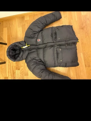 Svart Fjällräven jacka - Säljer nu min svarta fjällräven jacka då den aldrig kom till användning. Den är använd en gång och är i nyskick. Det är den tjockare modellen. Den är i storlek XSS och jag som har S vanligtvis på jackor passar den perfekt till! Kostar 7500 nypris:)